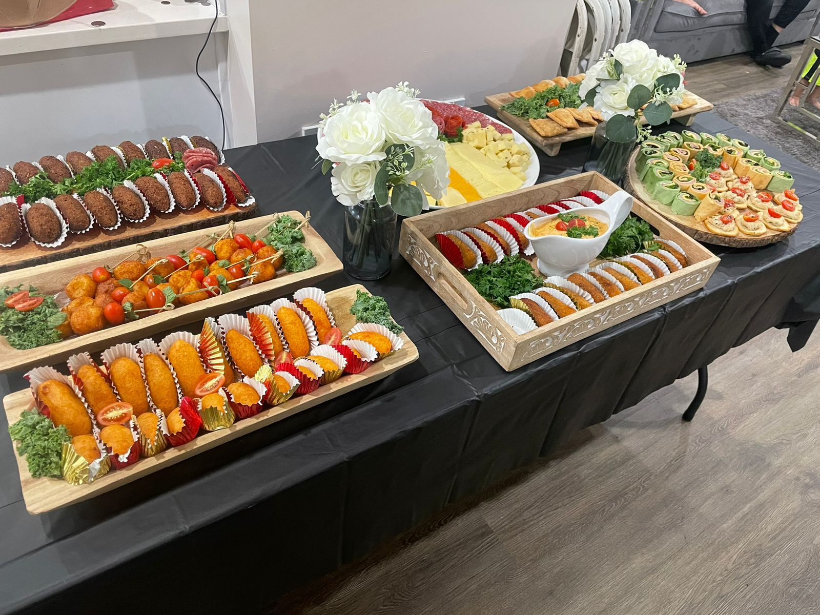 Mesa de catering dominicano con picaderas, frituras y comida casera